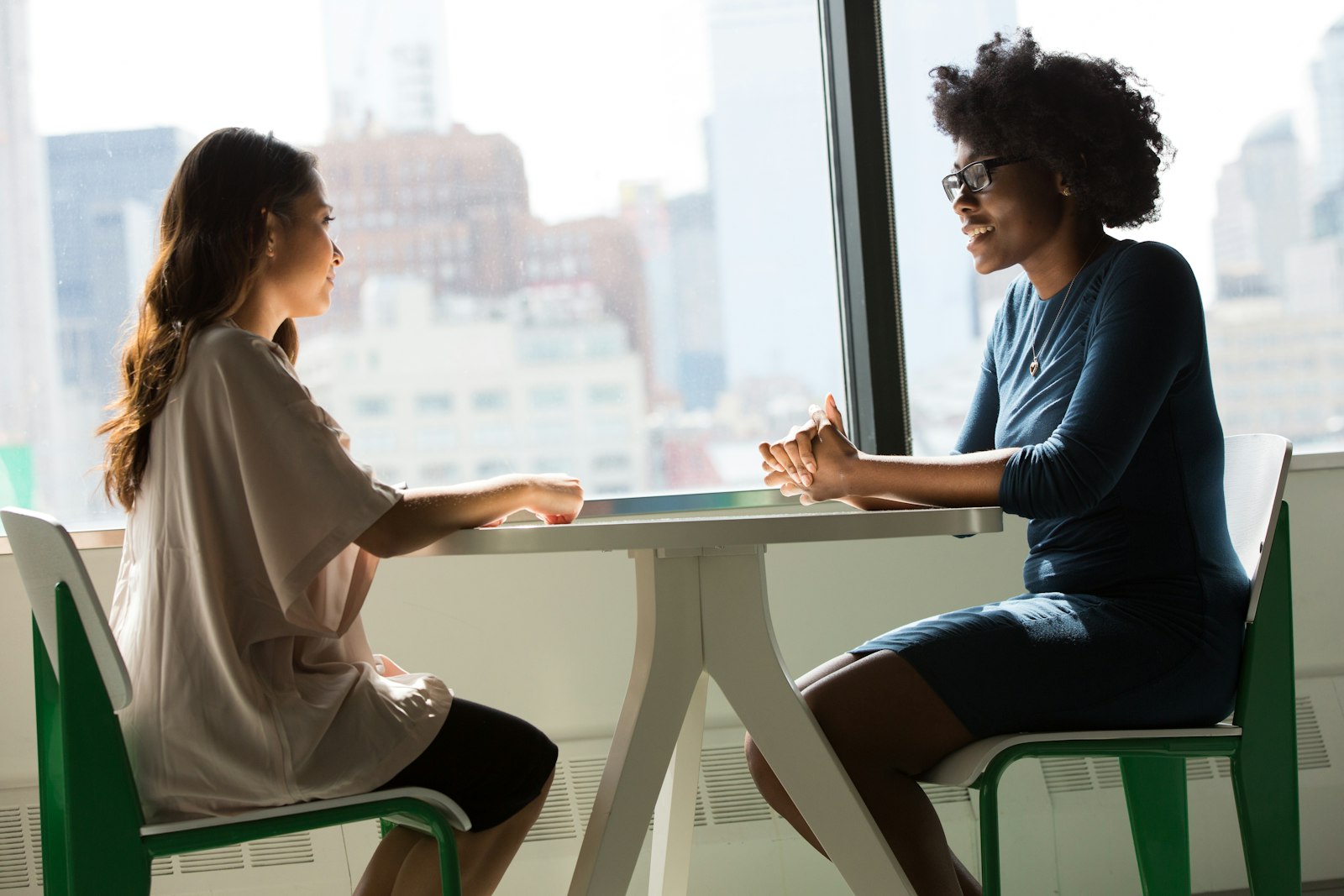 Two Dallas-Fort Worth business leaders discussing AI leadership strategy at a sunlit table